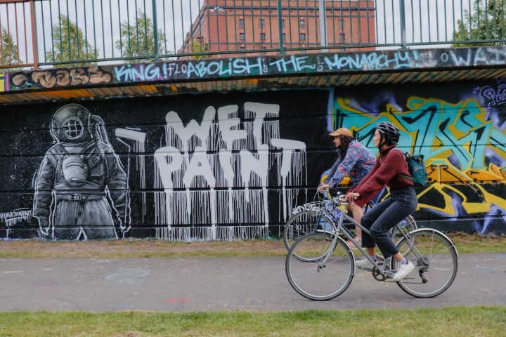 a man riding a bicycle in front of a building