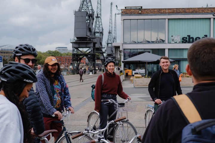 a group of people standing next to a bicycle